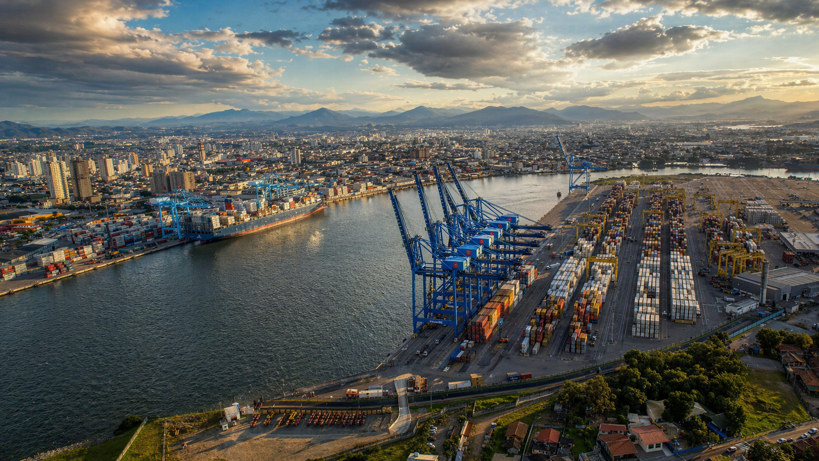 Vista aérea do Porto de Itajaí ao entardecer com a cidade ao fundo e o rio Itajaí-Açu em primeiro plano